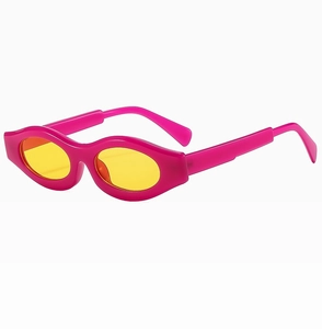 Close-up of Y2K style pink thick frame sunglasses with bright yellow oval lenses