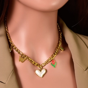 Gold layered necklace with heart, butterfly and tulip charms on a chic beige blazer