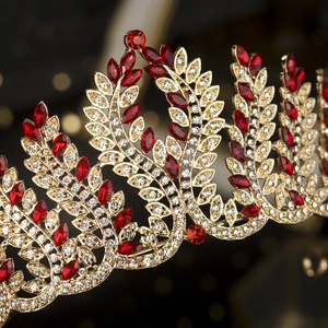 Detail of vintage Baroque crown featuring gold leaf patterns with red marquise rhinestones