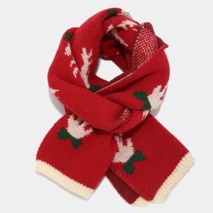 Detail of red Christmas knit scarf with festive reindeer pattern and ribbed cuffs