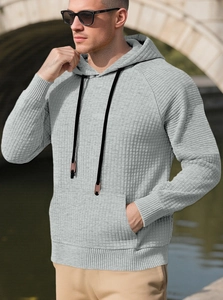 Detail eines hellgrauen Herren-Hoodies mit Waffelstrickmuster und Kängurutasche
