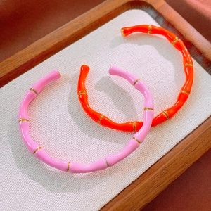 Dettaglio dei bracciali in smalto rosa e arancione in stile bambù in acciaio inossidabile