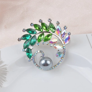 Luxury peacock brooch with large grey pearl and green crystals on a silver setting