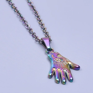 Macro shot of iridescent Hamsa Hand pendant with metallic finish on purple background
