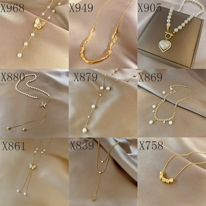 Collage de neuf colliers en acier titane avec cœurs dorés, perles et pendentifs papillon
