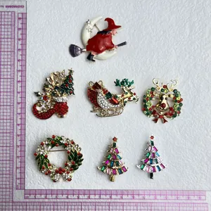 Detailansicht bunter Weihnachtsbroschen mit Strasssteinen und Emaille auf weißem Hintergrund