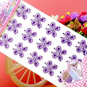 Detail von lila Kleeblatt-Kristallaufklebern auf pinkem Hintergrund für DIY-Dekoration
