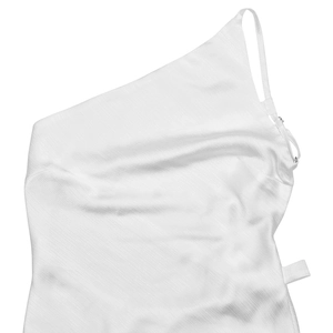 Detail of white one-shoulder dress showing smooth satin texture and elegant thin strap
