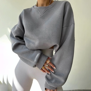 Detail of white INSTUNNING print on grey sweatshirt sleeve and ribbed knit cuff