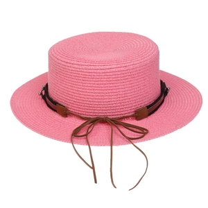 Detailed texture of pink straw sun hat with brown leather band and decorative metal accent