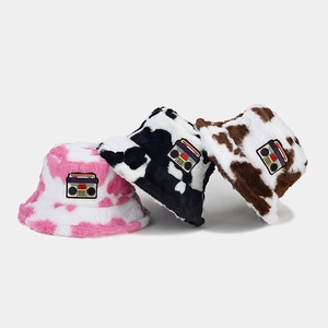 Plush cow print bucket hats in pink, black and brown with vintage radio patch