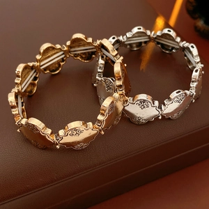 Détail de bracelets élastiques aux motifs évidés rétro en finitions or et argent antique
