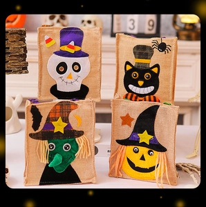Macro detail of four Halloween linen gift bags with pumpkin, skull, and witch felt appliques