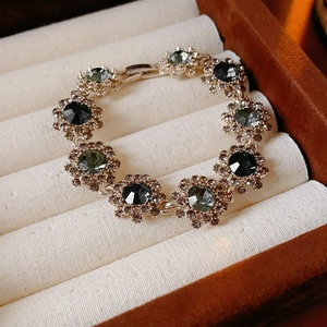 Detail of vintage flower bracelet with grey crystals on beige velvet jewelry box cushion
