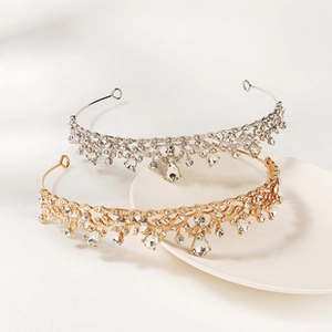 Detailed view of silver and gold bridal crowns with intricate crystals and teardrop gems