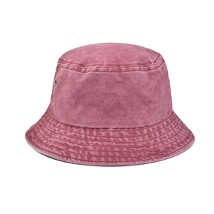 Dettaglio del cappello a secchiello in cotone lavato con texture vintage e occhielli in metallo