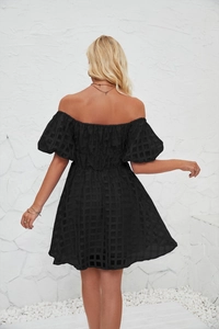Détail d'une mini robe noire à épaules dénudées avec texture en maille et manches bouffantes