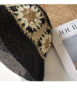 Detail of hand-woven bucket hat with floral pattern in black, beige and coffee colors