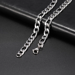 Close-up of stainless steel hip-hop cross chain necklace on premium black leather surface