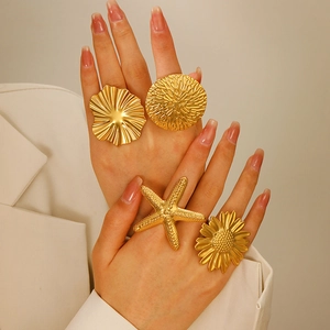 Golden chunky ring set featuring starfish, daisy, and coral designs on female fingers