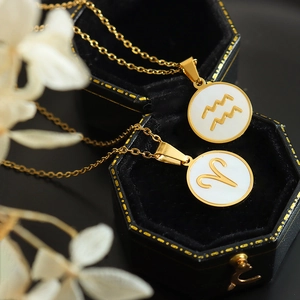 Elegant gold zodiac pendant necklace with white shell inlay featuring Aquarius and Aries