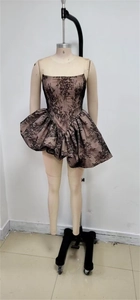 Detailansicht des schwarzen Spitzenkleids mit rosa Futter und gerafftem, bauschigem Saum