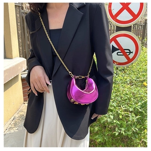 Detail of metallic purple crescent bag with gold chain and studded bottom on street