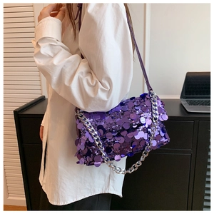 Detail of purple sequin shoulder bag featuring a chunky silver chain and leather strap