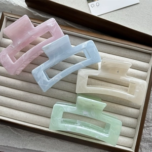 Set of four pastel hair claws with marble texture in pink, blue, white, and mint green