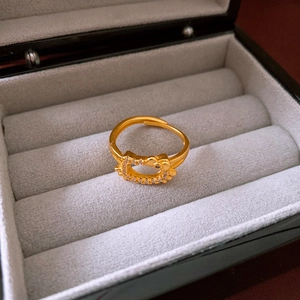 Macro shot of gold-plated Hello Kitty ring with zircon stones in a jewelry box