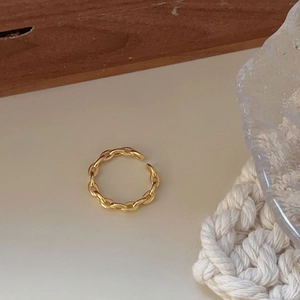 Minimalist gold chain link open ring on a wooden surface with aesthetic soft lighting
