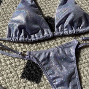 Detail of lavender holographic bikini with sparkling fabric and silver metal rings