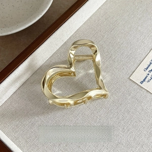 Detail view of heart-shaped gold metal hair claw clip with 6cm size measurement