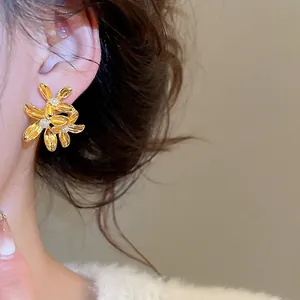 French vintage floral earrings with pearls and gold petals worn by a model