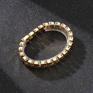 Detail of gold geometric chain link bracelet with small sphere accents on matte background