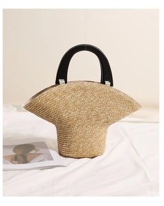 Dettaglio borsa in paglia intrecciata beige con manico in legno nero elegante
