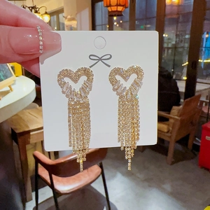 Detail shot of heart-shaped gold tassel earrings with S925 silver needles and zircons