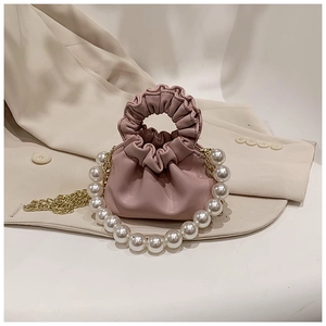 Detailed view of pink pleated mini handbag with pearl handle and golden chain strap