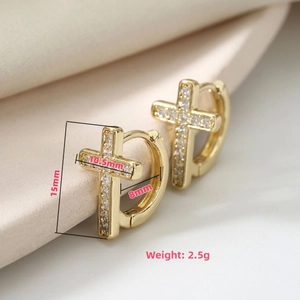Macro shot of gold cross huggie earrings with zircon pave and 15mm size dimensions