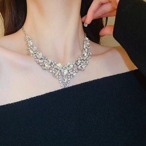 Dettaglio del set collana con strass scintillanti a goccia con design a V sul modello
