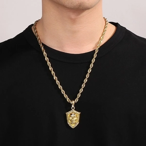 Macro shot of punk style skull shield pendant with rhinestones on golden twist chain