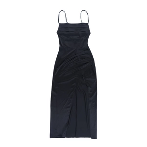 Detail of black satin slip dress showing side high slit and silky fabric texture