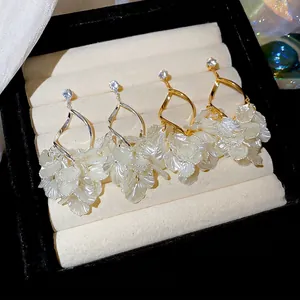 Elegant zircon pearl tassel earrings in gold and silver finish on jewelry display