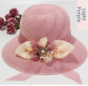 Macro detail of a light purple straw hat with silk flower, pearls and lace ribbon decoration