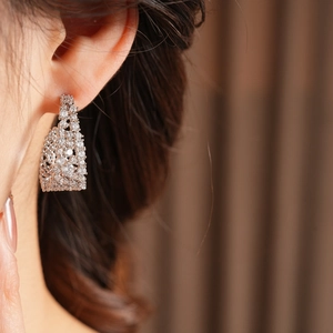 Dettaglio di modella che indossa orecchini a U in argento con brillanti cristalli di zircone