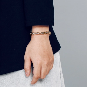 Detail of two-tone gold and silver titanium link bracelet on a wrist in close-up view