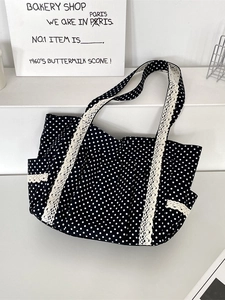 Polka dot canvas tote bag with cream lace trim and side pocket on white background
