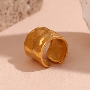 Dettaglio di un anello largo placcato oro 18K con texture martellata su base in pietra