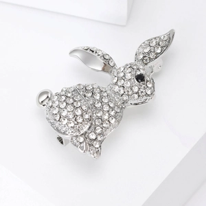 Close-up of a silver rabbit brooch with sparkling rhinestones and a black stone eye detail