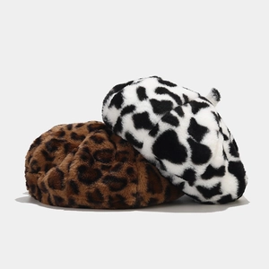 Détail de bérets en peluche aux motifs léopard et vache montrant la texture douce